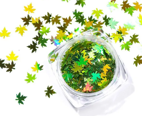 Pot de paillettes feuille d'érable vert holographique et feuilles éparpillées